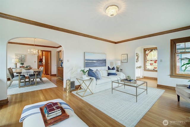 2663 37th Ave SW, Seattle, WA 98126 - living room with arched walkways, light wood-style flooring, a chandelier, and crown molding