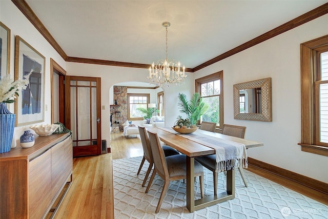 2663 37th Ave SW, Seattle, WA 98126 - dining space featuring arched walkways, light wood finished floors, a chandelier, and ornamental molding
