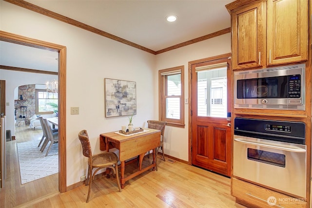 2663 37th Ave SW, Seattle, WA 98126 - kitchen with appliances with stainless steel finishes, light wood-style floors, a chandelier, crown molding, and arched walkways
