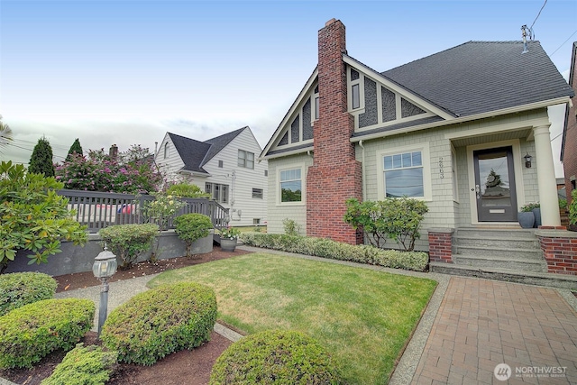 2663 37th Ave SW, Seattle, WA 98126 - view of front of house with a chimney, a front lawn, and roof with shingles