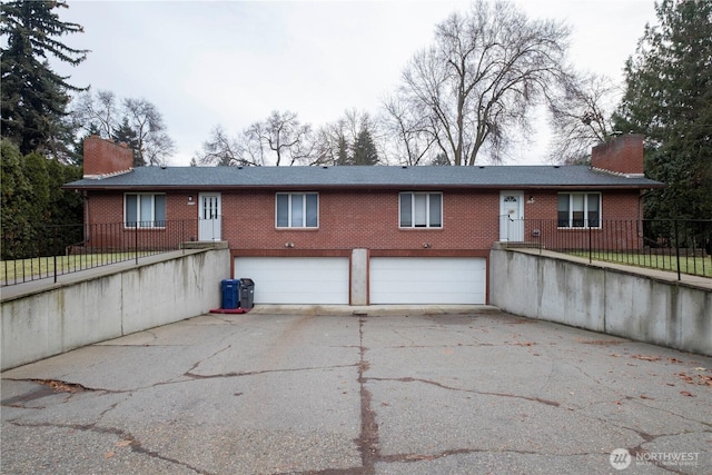 9724 N Wall St, Spokane, WA 99218 - rear view of house with a chimney, an attached garage, brick siding, and driveway