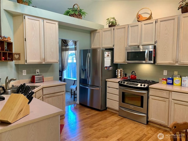 6214 145th St SE, Everett, WA 98208 - kitchen with stainless steel appliances, light countertops, light wood-style flooring, and light brown cabinets