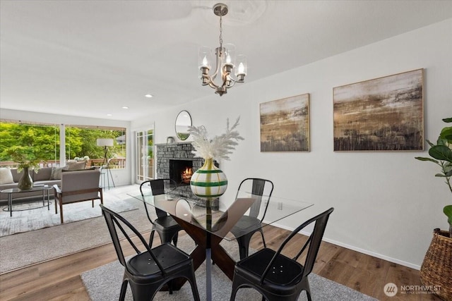 11404 SE 186th St, Renton, WA 98055 - dining space featuring a stone fireplace, a chandelier, wood finished floors, and recessed lighting