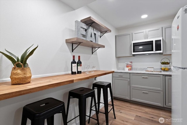 11404 SE 186th St, Renton, WA 98055 - kitchen featuring gray cabinets, open shelves, butcher block countertops, freestanding refrigerator, and a breakfast bar