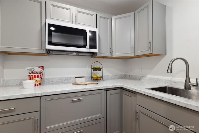 11404 SE 186th St, Renton, WA 98055 - kitchen with white microwave, gray cabinetry, and light stone countertops