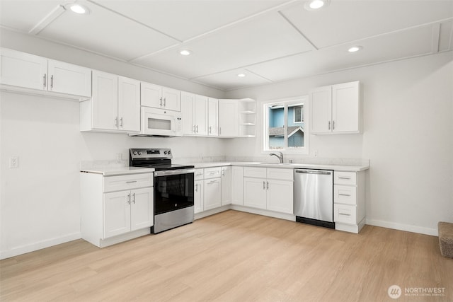 910 E 60th St, Tacoma, WA 98404 - kitchen featuring appliances with stainless steel finishes, open shelves, white cabinets, light countertops, and light wood-style floors