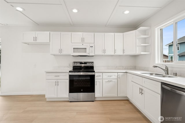 910 E 60th St, Tacoma, WA 98404 - kitchen with stainless steel appliances, white cabinets, recessed lighting, open shelves, and light wood-type flooring
