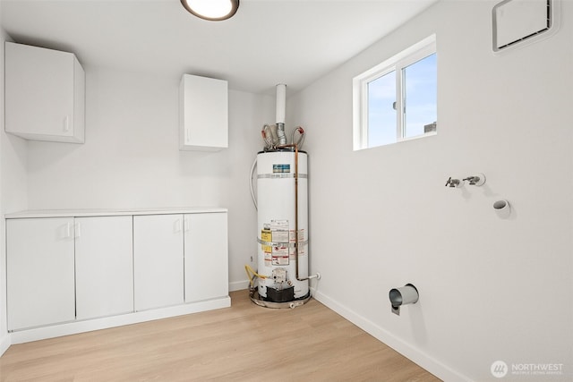 910 E 60th St, Tacoma, WA 98404 - washroom with water heater, cabinet space, and light wood-style floors