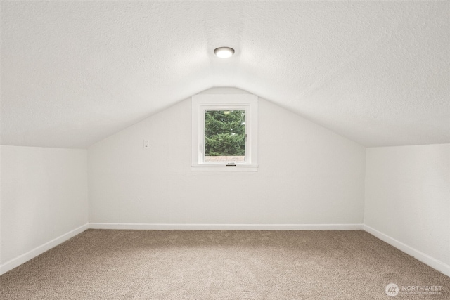 910 E 60th St, Tacoma, WA 98404 - additional living space featuring a textured ceiling, vaulted ceiling, and carpet