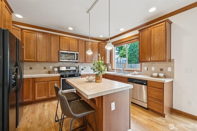 18231 2nd Pl W Unit A, Bothell, WA 98012 - kitchen featuring stainless steel appliances, light wood-style floors, brown cabinetry, and recessed lighting