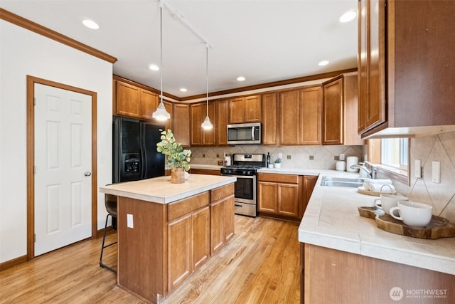 18231 2nd Pl W Unit A, Bothell, WA 98012 - kitchen featuring appliances with stainless steel finishes, light wood finished floors, brown cabinets, a center island, and decorative backsplash