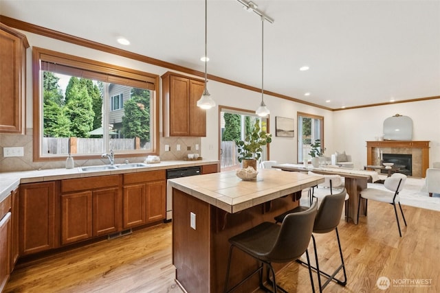 18231 2nd Pl W Unit A, Bothell, WA 98012 - kitchen with dishwasher, light wood-style floors, tile countertops, brown cabinets, and crown molding