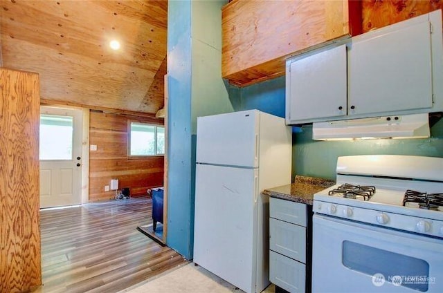 45401 Nellie Ln, Concrete, WA 98237 - kitchen with white appliances, under cabinet range hood, light wood finished floors, wood walls, and dark countertops
