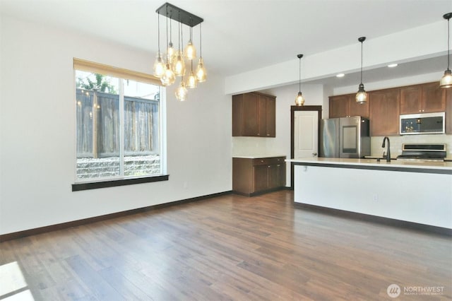 17723 3rd Ave SE, Bothell, WA 98012 - kitchen featuring stainless steel appliances, dark wood-style flooring, backsplash, pendant lighting, and light countertops