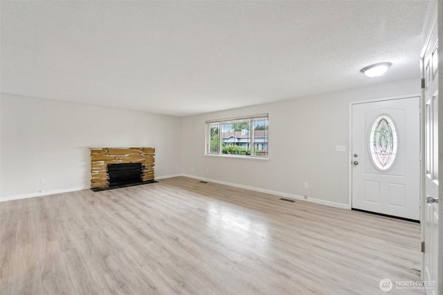 9442 S K St, Tacoma, WA 98444 - unfurnished living room featuring light wood-type flooring and a stone fireplace