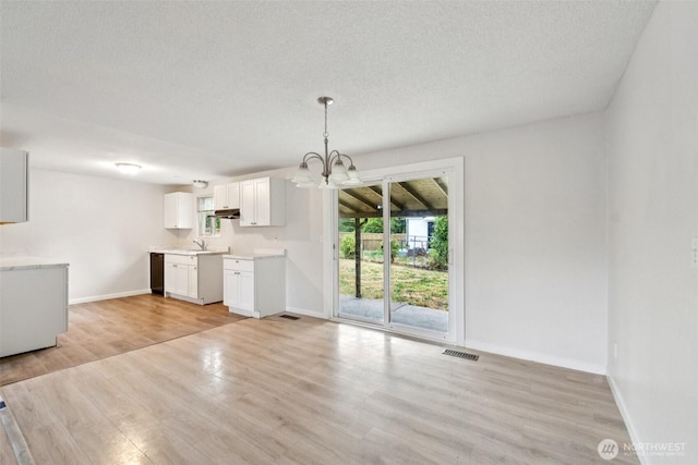 9442 S K St, Tacoma, WA 98444 - unfurnished living room featuring a chandelier, light wood finished floors, and a textured ceiling