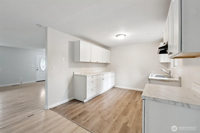 9442 S K St, Tacoma, WA 98444 - kitchen with light countertops, light wood-style floors, and white cabinetry