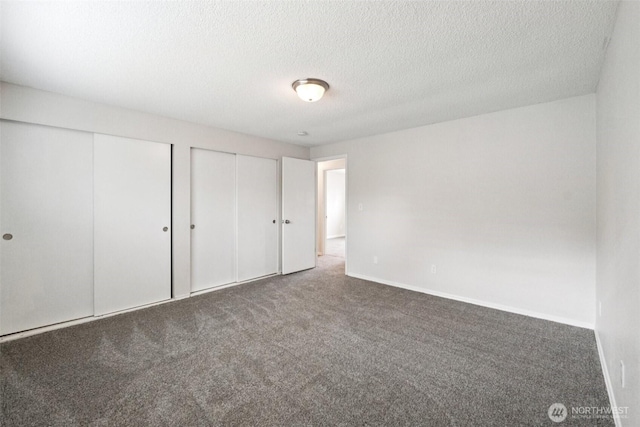 9442 S K St, Tacoma, WA 98444 - unfurnished bedroom with multiple closets, carpet, and a textured ceiling
