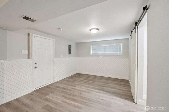 9442 S K St, Tacoma, WA 98444 - below grade area with a barn door, wood finished floors, wainscoting, and electric panel
