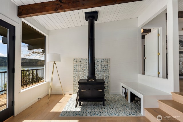 28605 Manzanita Beach Rd SW, Vashon, WA 98070 - detailed view of a wood stove, wood finished floors, nearby water, and a wood ceiling with exposed beams