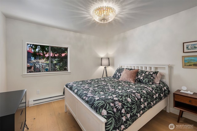 28605 Manzanita Beach Rd SW, Vashon, WA 98070 - bedroom with a baseboard radiator, a chandelier, and wood finished floors