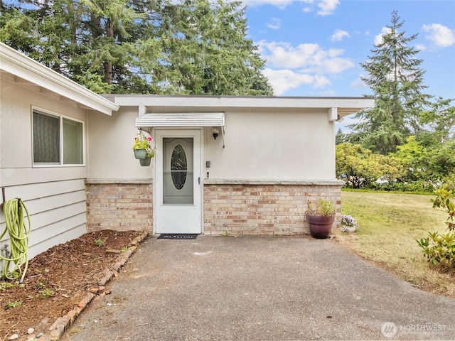 10818 108th St SW, Lakewood, WA 98498 - doorway to property featuring brick siding, a patio, and a yard