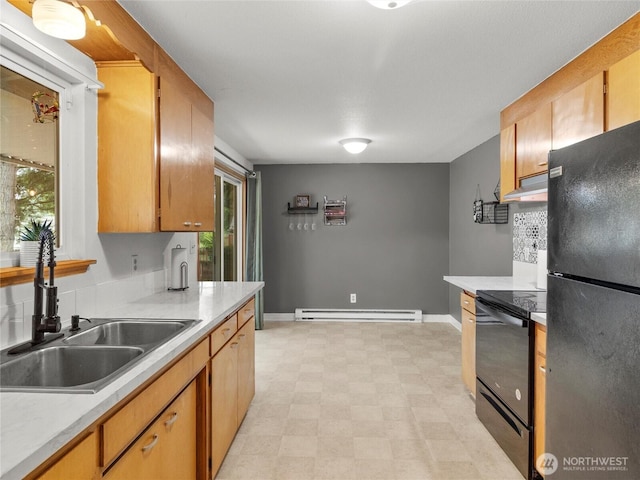 10818 108th St SW, Lakewood, WA 98498 - kitchen with black appliances, baseboard heating, under cabinet range hood, light countertops, and light floors