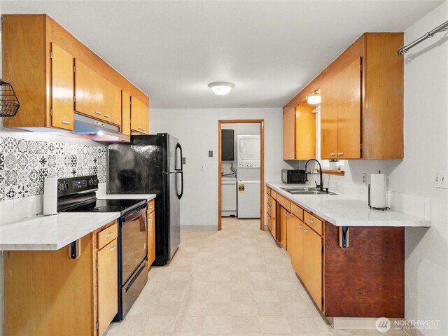 10818 108th St SW, Lakewood, WA 98498 - kitchen with black appliances, under cabinet range hood, light flooring, light countertops, and brown cabinets
