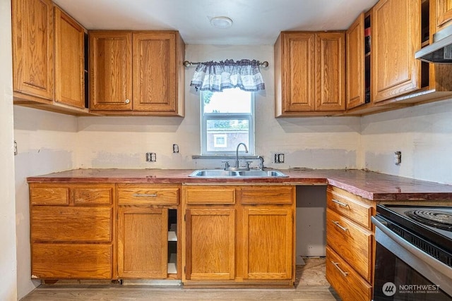 3800 Sleater Kinny Rd NE Unit 13, Olympia, WA 98506 - kitchen with under cabinet range hood, brown cabinets, black range with electric stovetop, and light wood finished floors