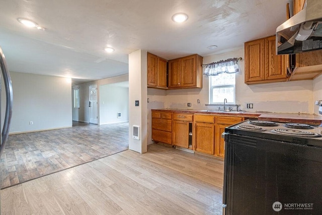 3800 Sleater Kinny Rd NE Unit 13, Olympia, WA 98506 - kitchen featuring black range with electric cooktop, ventilation hood, brown cabinets, and light wood-style flooring