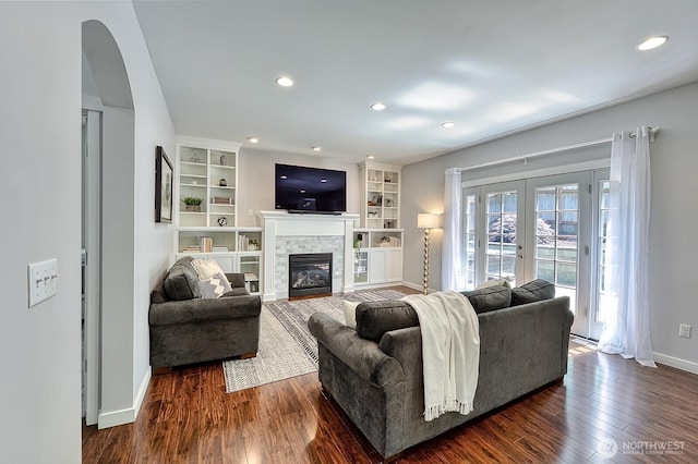 3606 Tree Farm Ct, Bellingham, WA 98226 - living room featuring dark wood-style flooring, a glass covered fireplace, arched walkways, built in features, and recessed lighting