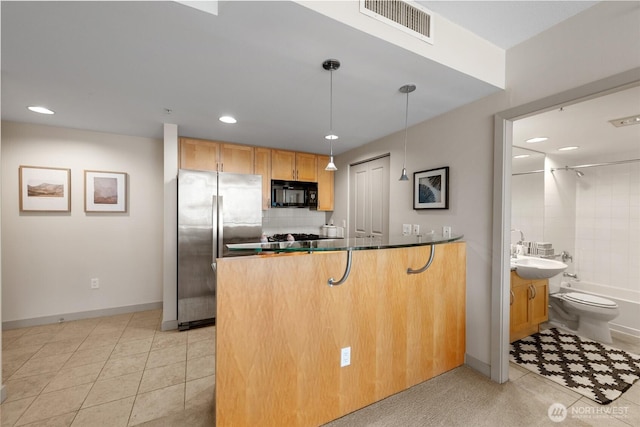 2929 1st Ave Unit 721, Seattle, WA 98121 - kitchen featuring black microwave, freestanding refrigerator, a peninsula, light tile patterned floors, and recessed lighting