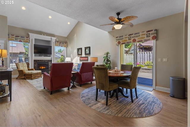 126 28th St NW, Long Beach, WA 98631 - dining space with a ceiling fan, a warm lit fireplace, vaulted ceiling, light wood-style flooring, and recessed lighting