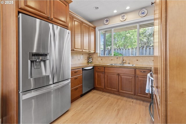 126 28th St NW, Long Beach, WA 98631 - kitchen featuring appliances with stainless steel finishes, light wood-type flooring, brown cabinets, tasteful backsplash, and recessed lighting