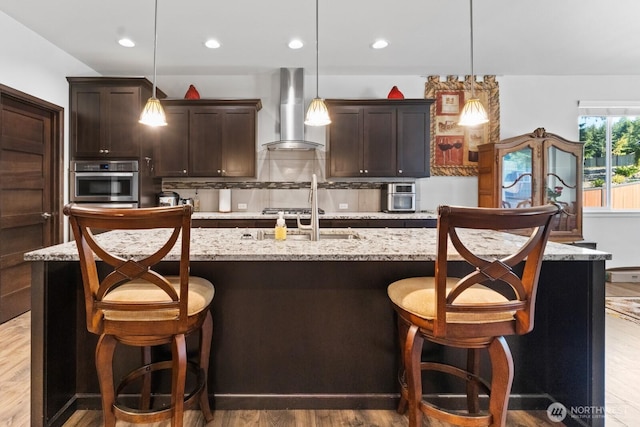 4831 Skylark St NE, Olympia, WA 98516 - kitchen with wall chimney range hood, dark brown cabinetry, decorative backsplash, wood finished floors, and recessed lighting