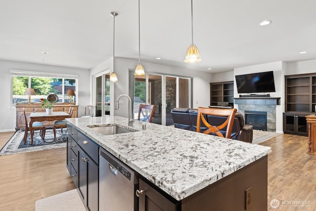 4831 Skylark St NE, Olympia, WA 98516 - kitchen with stainless steel dishwasher, light wood-style flooring, a tile fireplace, recessed lighting, and decorative light fixtures