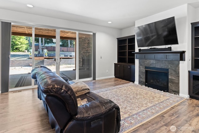 4831 Skylark St NE, Olympia, WA 98516 - living room with wood finished floors, a tiled fireplace, and recessed lighting