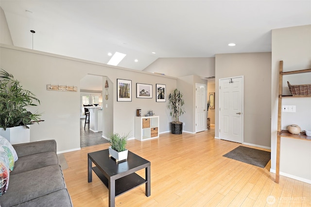 25920 202nd Ave SE, Covington, WA 98042 - living area with arched walkways, vaulted ceiling, light wood-style flooring, recessed lighting, and a skylight