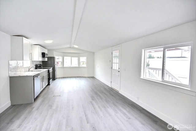210 37th St SE Unit 35, Auburn, WA 98002 - kitchen featuring stainless steel appliances, light countertops, light wood-style floors, white cabinets, and tasteful backsplash