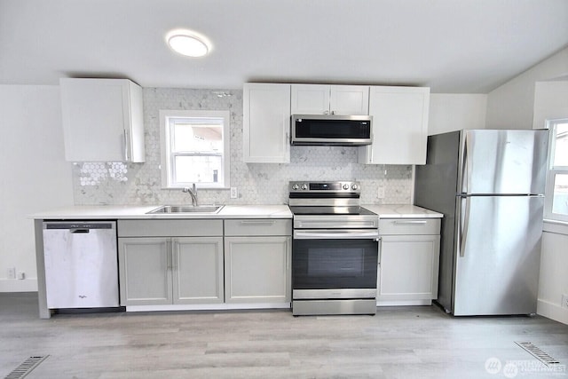 210 37th St SE Unit 35, Auburn, WA 98002 - kitchen with stainless steel appliances, tasteful backsplash, light wood-type flooring, and light countertops