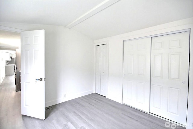 210 37th St SE Unit 35, Auburn, WA 98002 - unfurnished bedroom featuring wood finished floors, vaulted ceiling, and two closets