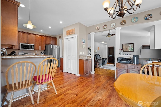 1918 Tundra Loop, Mount Vernon, WA 98273 - kitchen featuring appliances with stainless steel finishes, ornate columns, light wood-type flooring, a peninsula, and recessed lighting