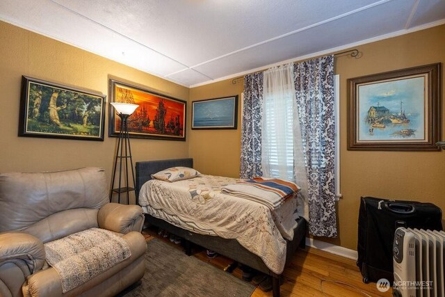 1427 E 3rd St, Port Angeles, WA 98362 - bedroom featuring radiator heating unit, wood finished floors, and crown molding