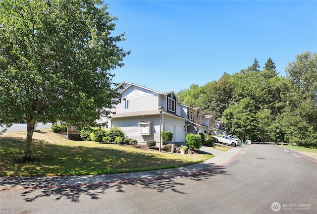 2711 SE 10th St Unit 1099, Renton, WA 98058 - view of front of house featuring an attached garage, a front yard, driveway, and board and batten siding