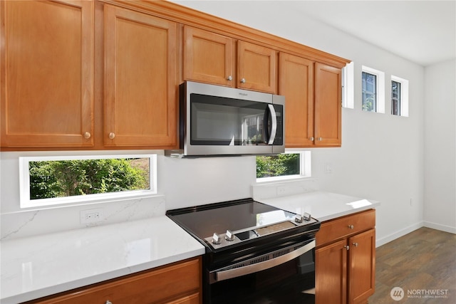 2711 SE 10th St Unit 1099, Renton, WA 98058 - kitchen with electric range oven, stainless steel microwave, dark wood-type flooring, brown cabinetry, and backsplash
