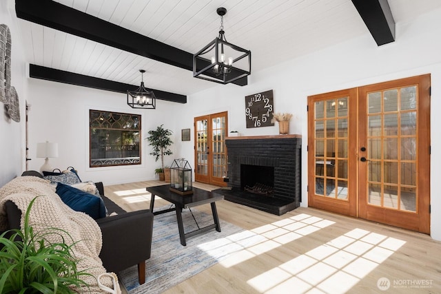 4020 N 34th St, Tacoma, WA 98407 - living room with french doors, a chandelier, wood finished floors, a wooden ceiling with exposed beams, and a brick fireplace