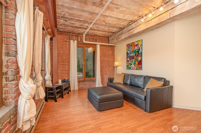 1507 Western Ave Unit R203, Seattle, WA 98101 - living area featuring track lighting, wood finished floors, brick wall, wooden ceiling, and a baseboard radiator
