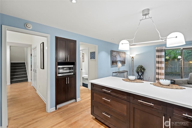 2109 130th Pl SE, Bellevue, WA 98005 - kitchen featuring light wood finished floors, light countertops, dark brown cabinetry, and stainless steel microwave