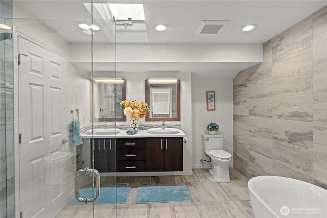 2109 130th Pl SE, Bellevue, WA 98005 - full bathroom featuring a freestanding bath, double vanity, a skylight, and recessed lighting