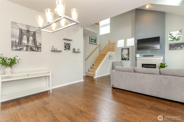6409 Francis Ave SE, Auburn, WA 98092 - living area featuring a high ceiling, wood finished floors, stairway, a tile fireplace, and a chandelier